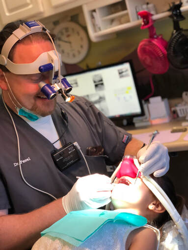 Happy Pueblo Dentist Performing Kids Dentistry